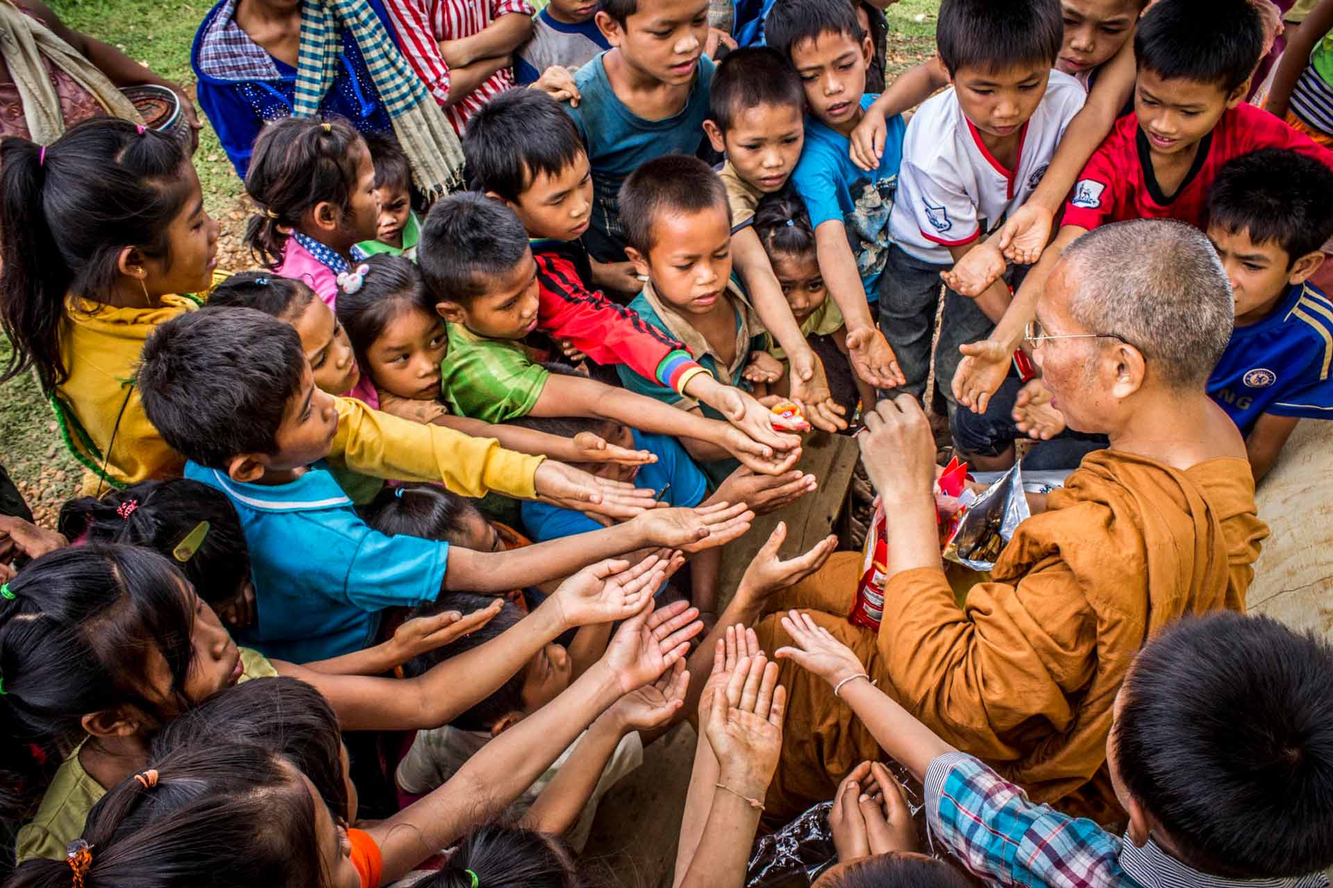 Man giving snacks to a group of children