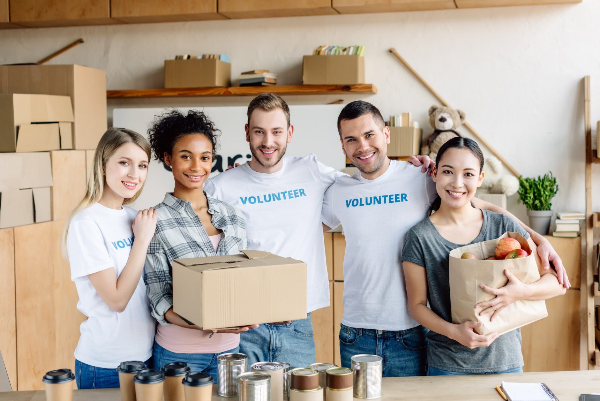 Smiling volunteers packing food donations